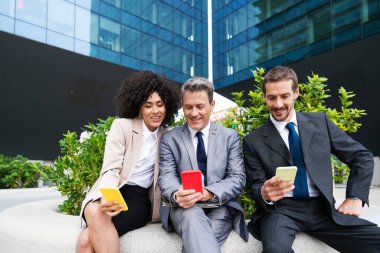 Multiracial group of business people bonding outdoors - International business corporate team wearing elegant suit meeting in a business park