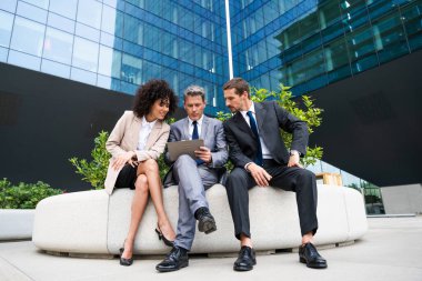 Multiracial group of business people bonding outdoors - International business corporate team wearing elegant suit meeting in a business park