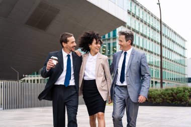 Multiracial group of business people bonding outdoors - International business corporate team wearing elegant suit meeting in a business park
