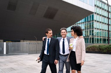 Multiracial group of business people bonding outdoors - International business corporate team wearing elegant suit meeting in a business park