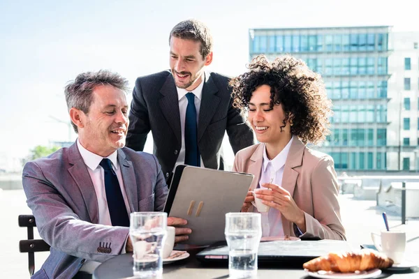 Senior businessman, caucasian man and beautiful hispanic businesswoman meeting in a bar restaurant  - Three colleagues bonding in a cafe after work