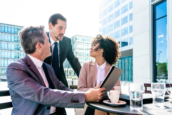 Senior businessman, caucasian man and beautiful hispanic businesswoman meeting in a bar restaurant  - Three colleagues bonding in a cafe after work