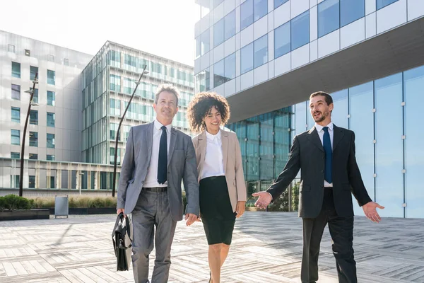 Multiracial group of business people bonding outdoors - International business corporate team wearing elegant suit meeting in a business park