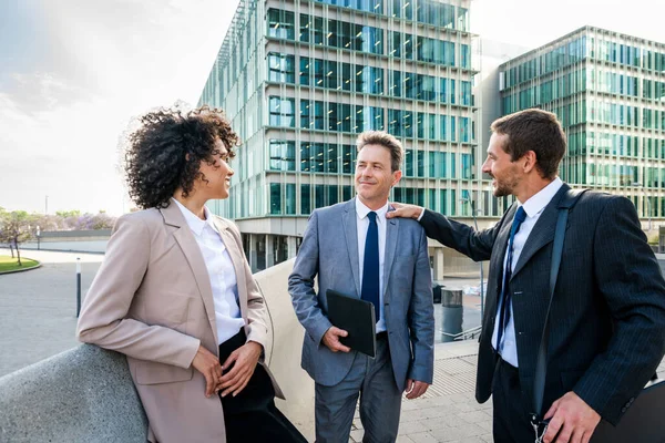 Multiracial group of business people bonding outdoors - International business corporate team wearing elegant suit meeting in a business park