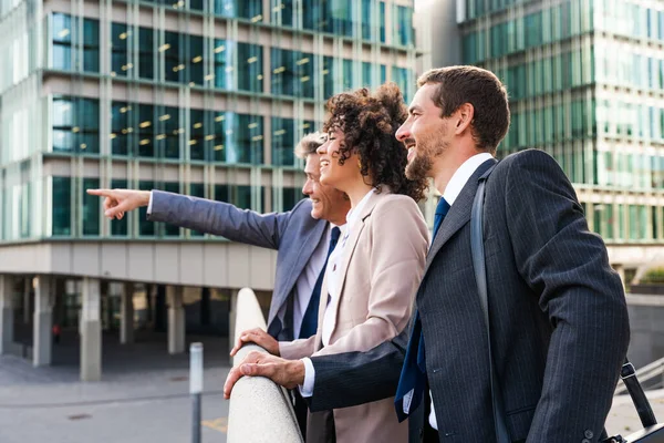 Multiracial group of business people bonding outdoors - International business corporate team wearing elegant suit meeting in a business park