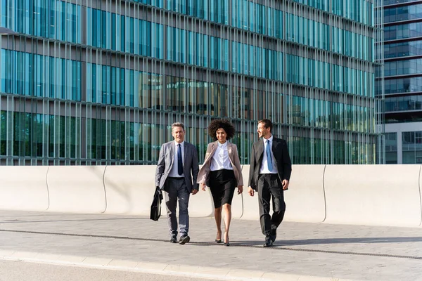 Multiracial group of business people bonding outdoors - International business corporate team wearing elegant suit meeting in a business park