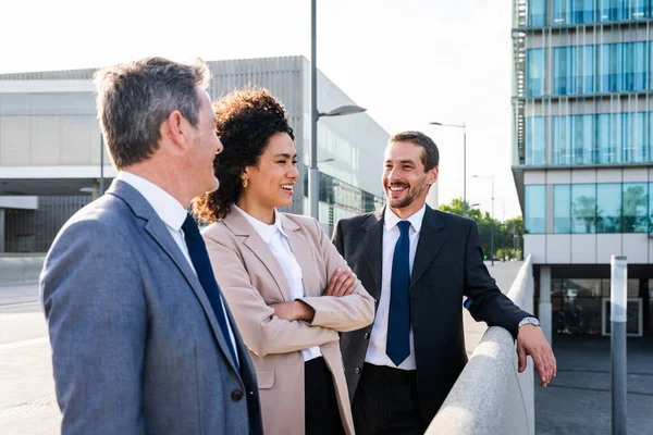 Multiracial group of business people bonding outdoors - International business corporate team wearing elegant suit meeting in a business park
