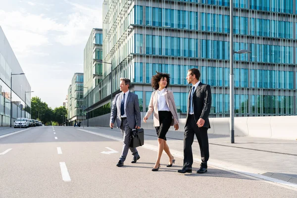 Multiracial group of business people bonding outdoors - International business corporate team wearing elegant suit meeting in a business park