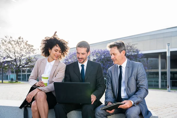 Multiracial group of business people bonding outdoors - International business corporate team wearing elegant suit meeting in a business park
