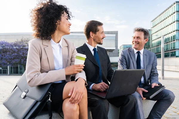 Multiracial group of business people bonding outdoors - International business corporate team wearing elegant suit meeting in a business park