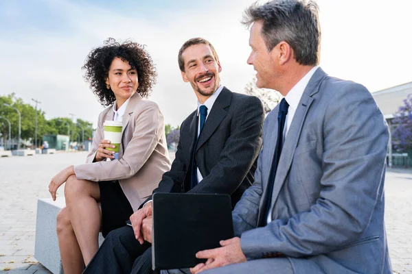 Multiracial group of business people bonding outdoors - International business corporate team wearing elegant suit meeting in a business park