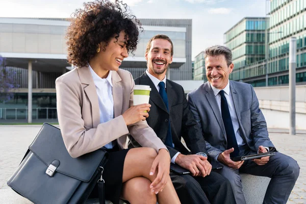 Multiracial group of business people bonding outdoors - International business corporate team wearing elegant suit meeting in a business park