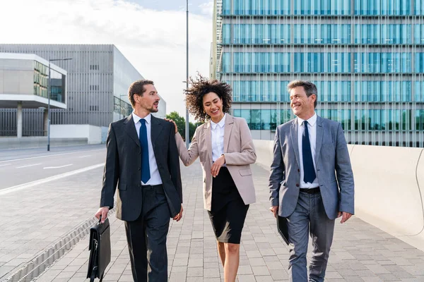 Multiracial group of business people bonding outdoors - International business corporate team wearing elegant suit meeting in a business park