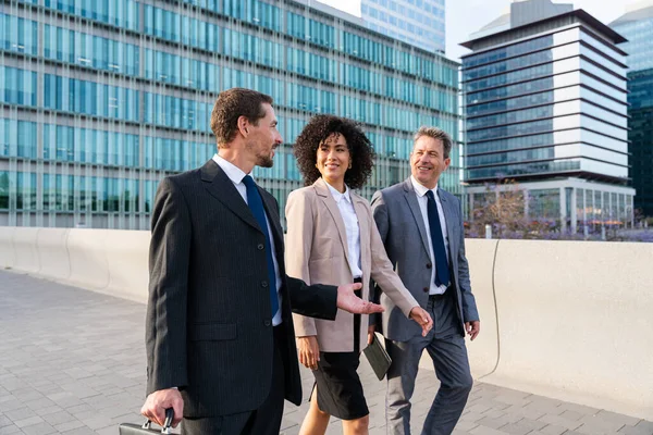 Multiracial group of business people bonding outdoors - International business corporate team wearing elegant suit meeting in a business park