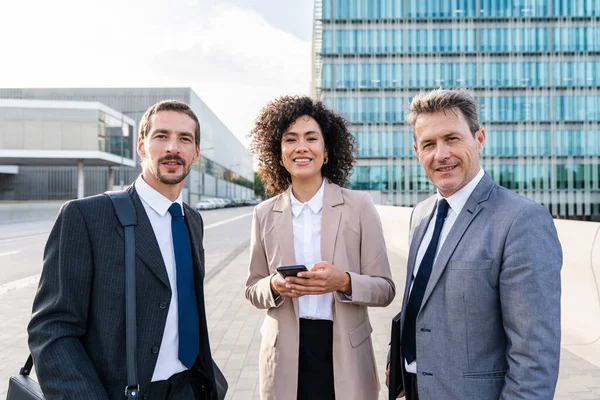 Multiracial group of business people bonding outdoors - International business corporate team wearing elegant suit meeting in a business park
