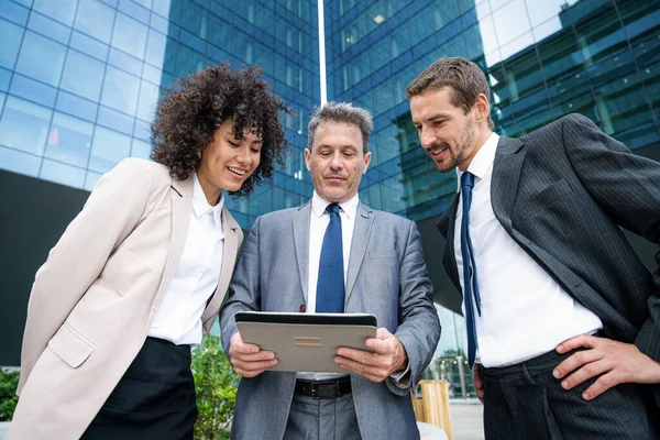 Multiracial group of business people bonding outdoors - International business corporate team wearing elegant suit meeting in a business park