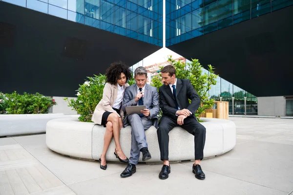 Multiracial group of business people bonding outdoors - International business corporate team wearing elegant suit meeting in a business park