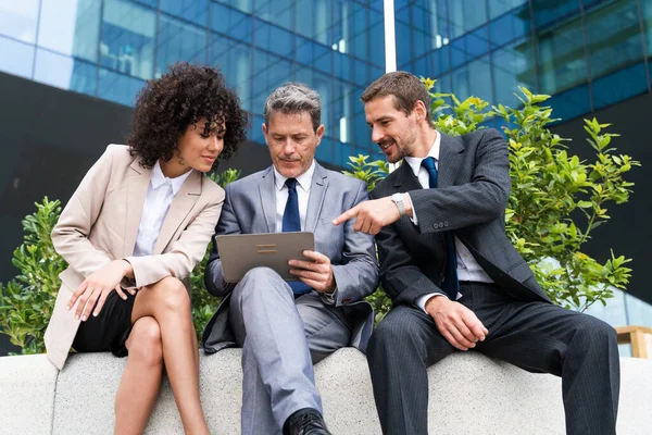 Multiracial group of business people bonding outdoors - International business corporate team wearing elegant suit meeting in a business park
