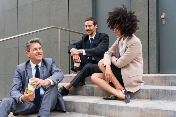 Multiracial group of business people bonding outdoors - International business corporate team wearing elegant suit meeting in a business park