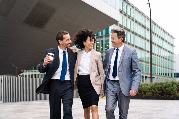 Multiracial group of business people bonding outdoors - International business corporate team wearing elegant suit meeting in a business park