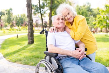 Açık havada engelli güzel bir çift - 60, 70, 80 yaşlarındaki yaşlı insanlar birlikte eğleniyor ve zaman geçiriyorlar, yaşlılar, kıdemliler, sağlık hizmetleri ve yaşlılık hakkında kavramlar