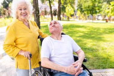 Açık havada engelli güzel bir çift - 60, 70, 80 yaşlarındaki yaşlı insanlar birlikte eğleniyor ve zaman geçiriyorlar, yaşlılar, kıdemliler, sağlık hizmetleri ve yaşlılık hakkında kavramlar