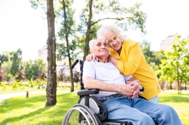 Açık havada engelli güzel bir çift - 60, 70, 80 yaşlarındaki yaşlı insanlar birlikte eğleniyor ve zaman geçiriyorlar, yaşlılar, kıdemliler, sağlık hizmetleri ve yaşlılık hakkında kavramlar