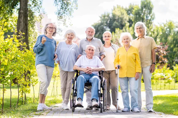 Group of happy elderly people bonding outdoors at the park - Old people in the age of 60, 70, 80 having fun and spending time together, concepts about elderly, seniority and wellness aging