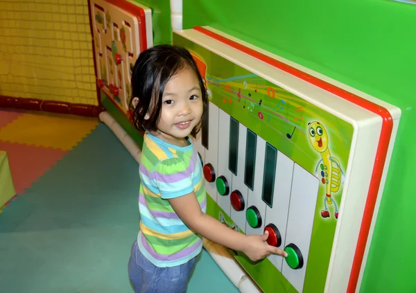 Klein meisje, grote piano spelen Stockafbeelding