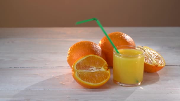 Gesunder Orangensaft im Glas und Orangen. Saftspritzer in Zeitlupe. Wermutstropfen. Anzeige — Stockvideo
