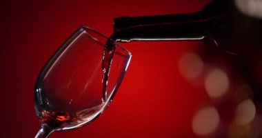 Arka planda izole edilmiş şarap kadehindeki kırmızı şarap. Düşüş yüzeye düşer ve dalgalar yaratır. Güzel Bockeh. Reklam çekimi. Yönlendir
