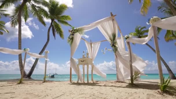 Lussuosa cerimonia nuziale sull'oceano, spiaggia caraibica. Sedie bianche e altare disposti sulla spiaggia per il matrimonio con fiori gialli e mare sullo sfondo — Video Stock