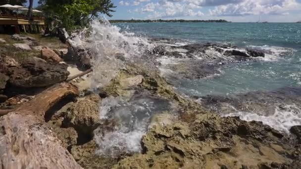 Vlny se lámou o skály v modrém oceánu. Mořské vlny na krásné pláži letecký pohled drone 4k výstřel. Dominikánská republika — Stock video
