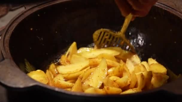 Готовить картошку фри во фритюрнице, хрустящую картошку фри, концепцию фастфуда. Человек лучший повар Концепции. Медленное движение 4K — стоковое видео