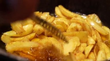 Aileye yemek pişirmek. Patates. Patatesleri tavada karıştıran kız.