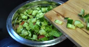 Ev mutfağında yemek hazırlıyorum. Kahvaltı hazırlamak ya da restoranda öğle yemeği. Fast food yakın plan. Erkek bir şef peynirli salatalık ve salatalı büyük bir sandviçin üzerine sos döker.