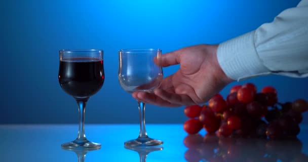 ボトルから赤ワインをシチリア島のブドウ畑にある2つのグラスに注ぎます。エトナ火山を背景に赤ワインをグラスに注ぐソムリエ。赤ワインでワイングラスを埋めるクローズアップ。広告 — ストック動画