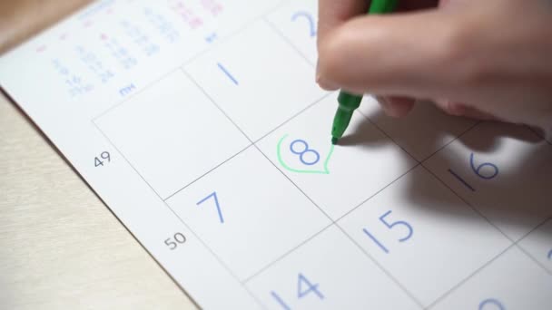 8 marca dzień kobiet. Dziewczyna zaznacza datę urlopu w kalendarzu — Wideo stockowe