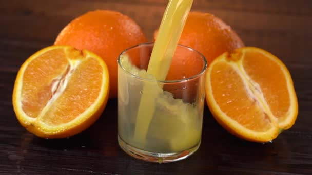 新鮮なオレンジジュースのガラスは、デトックス飲料を提供しています。男はリフレッシュのためにガラスに新鮮なデトックスオレンジジュースを注ぐ。新鮮なデトックスオレンジジュースドリンクはビタミンCを高めることができます。. — ストック動画