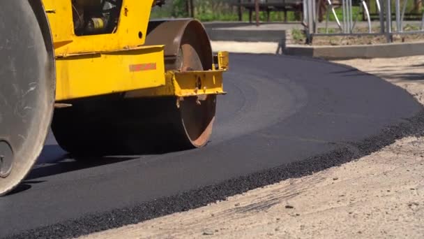 Vägvält gör ny väg. Asfaltläggare som använder asfalt på en motorväg. Utrustning som används för att automatiskt applicera asfalt på gatan. Enorma tunga maskiner asfalt på vägen. — Stockvideo