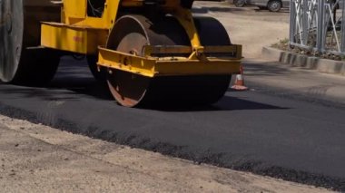 Yol silindiri yeni bir asfalt yol yapımında çalışıyor. Yol tamiri. Yeni bir yol yapıyorum. Ulaşım sorunu kavramı. Yavaş Hareket