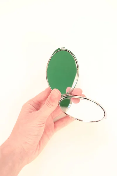 el küçük bir ayna tutar