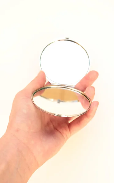 el küçük bir ayna tutar