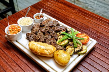 Izgara domuz pirzolası, sebze ve sos.