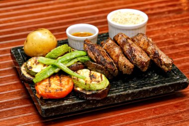 Tabakta ızgara et ve sebze.