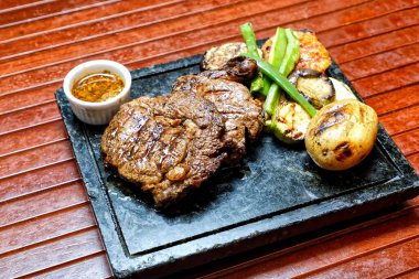 Tahtada sebzeli ve baharatlı ızgara biftek.