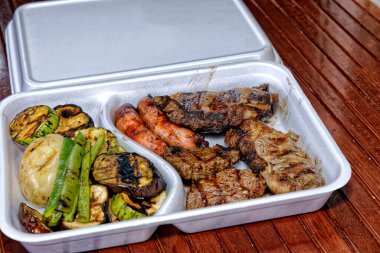 Tabakta ızgara et ve sebze.