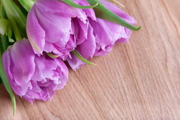 Ramo de tulipanes sobre fondo de madera — Foto de Stock