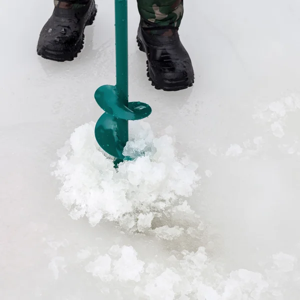 男は氷に穴をドリルします。 — ストック写真