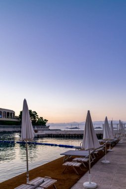 Güneşli şemsiyeler ve şezlonglar sabahın erken saatlerinde Monako 'da bir plajda